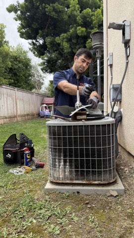 Technician removing AC condenser fan
