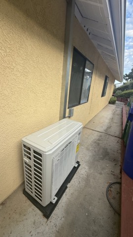 Ductless mini-split condenser by wall