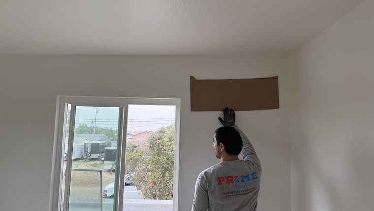 Technician cutting indoor wall penetration