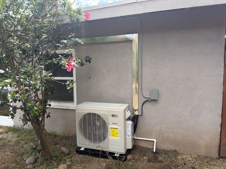 Mini-split condenser beside stucco wall