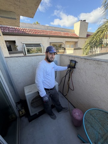 Tech checking refrigerant gauges at mini-split